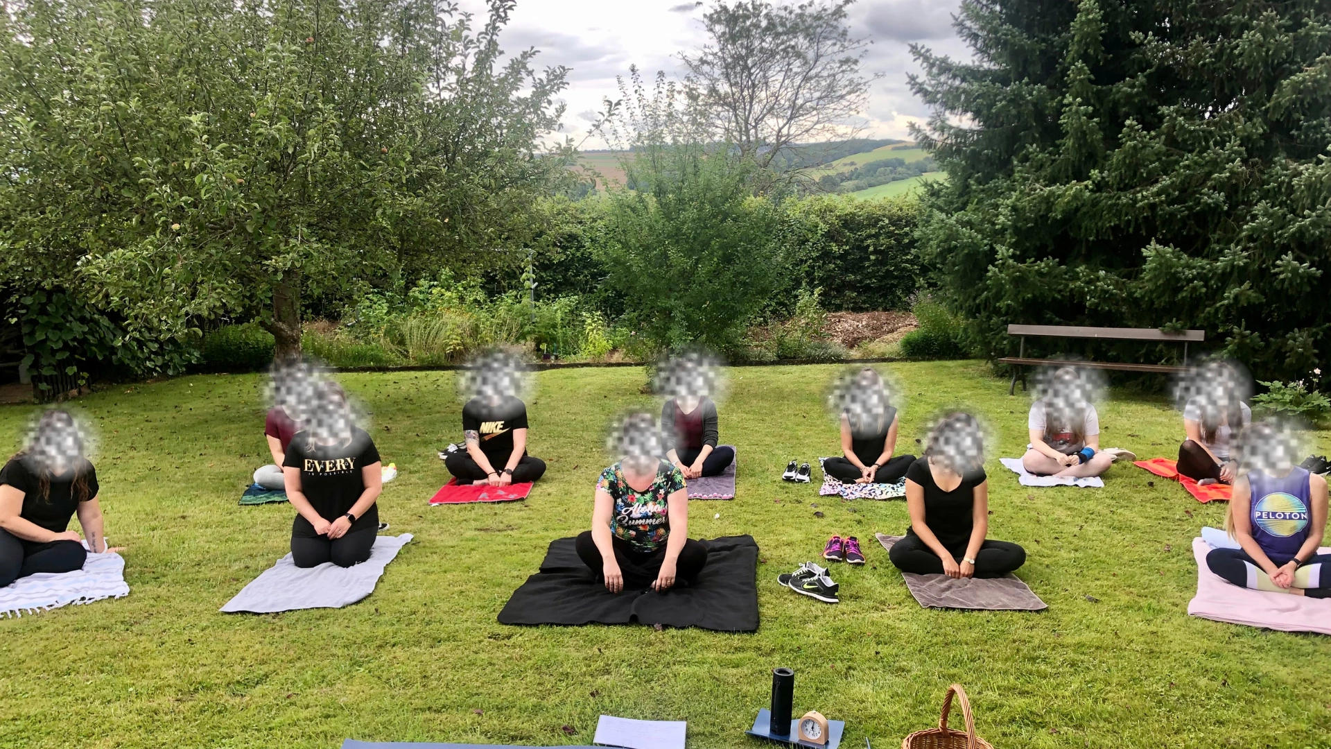 Eine Yogagruppe übt draußen im Garten